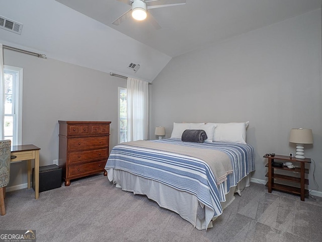 carpeted bedroom with multiple windows, ceiling fan, and vaulted ceiling