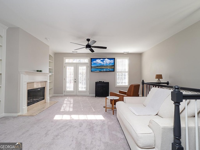 living room featuring a fireplace, french doors, light carpet, ceiling fan, and built in shelves