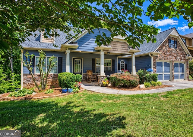 craftsman-style house with covered porch, a front yard, and a garage