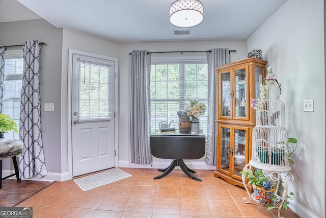 foyer entrance with light tile patterned floors and a wealth of natural light