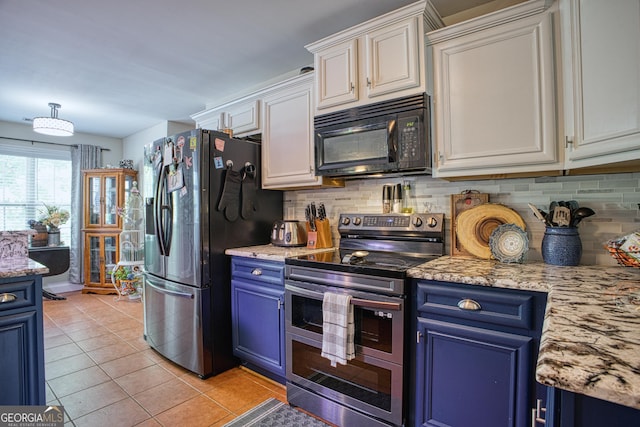 kitchen featuring appliances with stainless steel finishes, blue cabinetry, light tile patterned floors, decorative backsplash, and white cabinetry