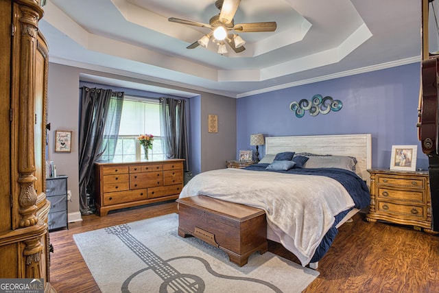 bedroom featuring a raised ceiling, ceiling fan, crown molding, and dark hardwood / wood-style flooring