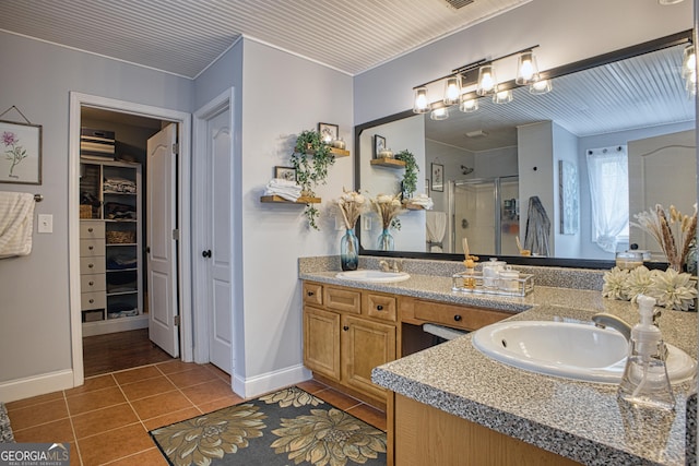 bathroom featuring a shower with door, vanity, and tile patterned floors