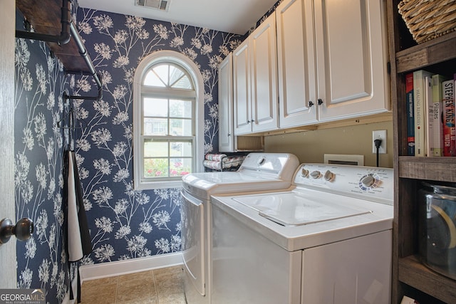 clothes washing area featuring independent washer and dryer and cabinets