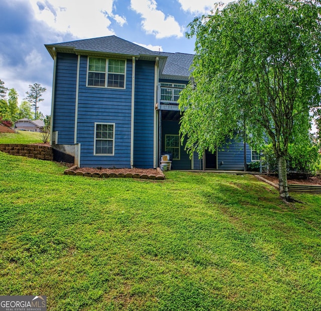 rear view of house featuring a lawn