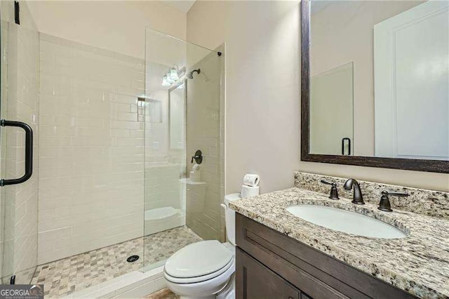 bathroom featuring toilet, walk in shower, and vanity