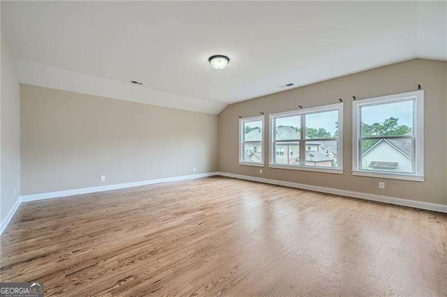 empty room featuring lofted ceiling and light hardwood / wood-style floors