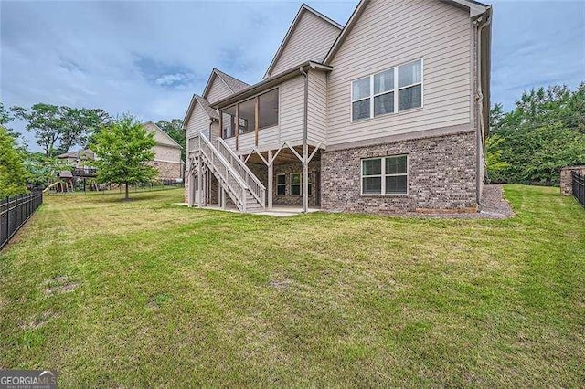 back of property featuring a lawn and a sunroom