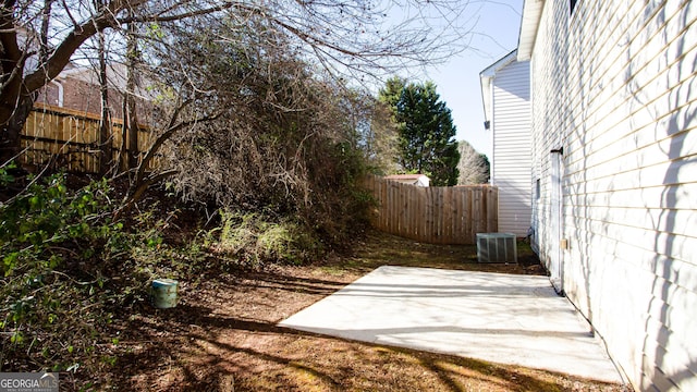 view of yard with central air condition unit and a patio area