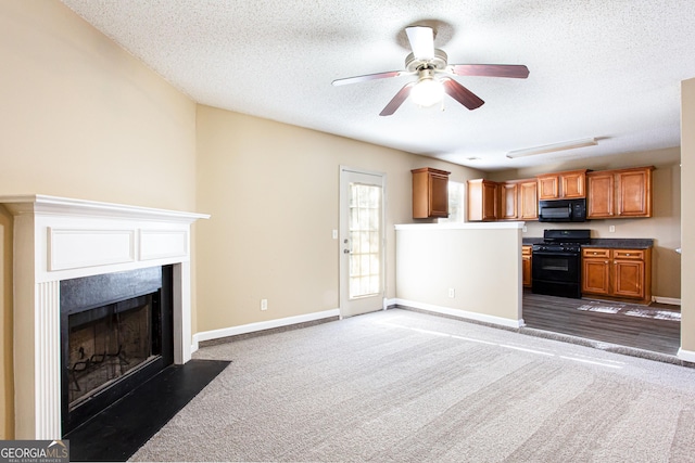 kitchen featuring a textured ceiling, ceiling fan, black appliances, and dark colored carpet