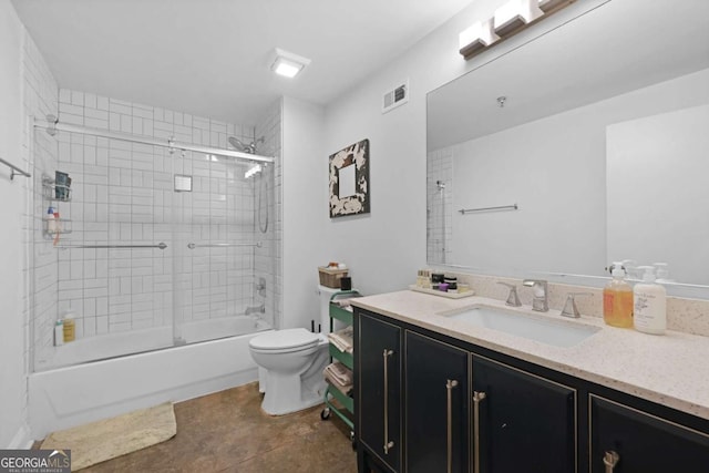 full bathroom featuring toilet, vanity, tile patterned floors, and combined bath / shower with glass door