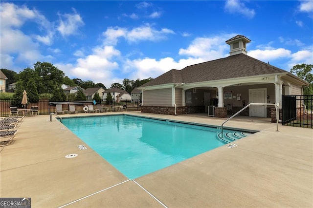 pool with fence and a patio area
