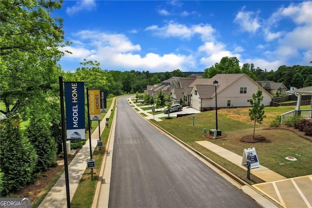 view of road featuring curbs, traffic signs, and a residential view