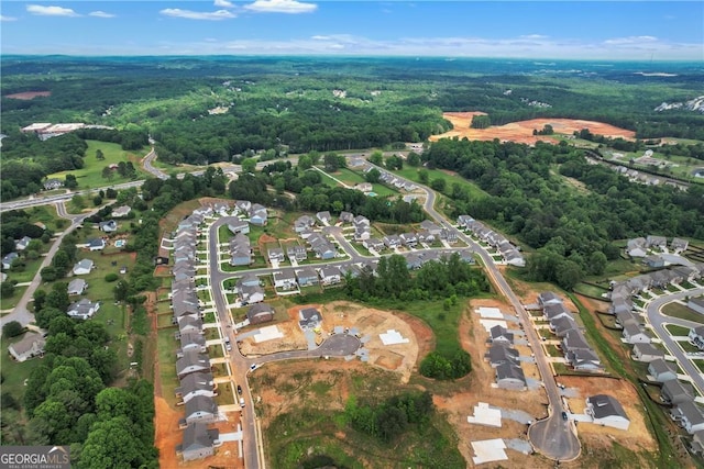 drone / aerial view featuring a residential view and a forest view