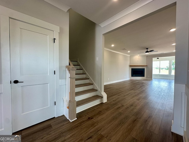 stairway featuring wood finished floors, a fireplace, baseboards, recessed lighting, and a ceiling fan