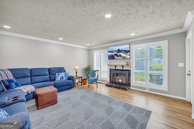 living room with a textured ceiling, hardwood / wood-style floors, plenty of natural light, and crown molding