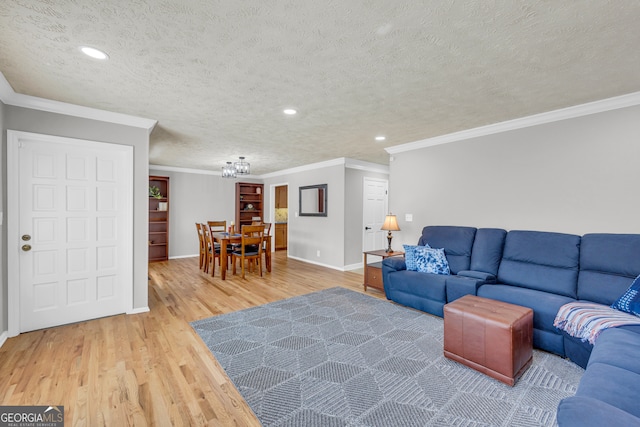 living room featuring a textured ceiling, ornamental molding, and wood-type flooring