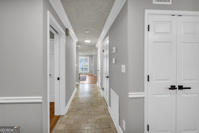 hallway with a textured ceiling and ornamental molding