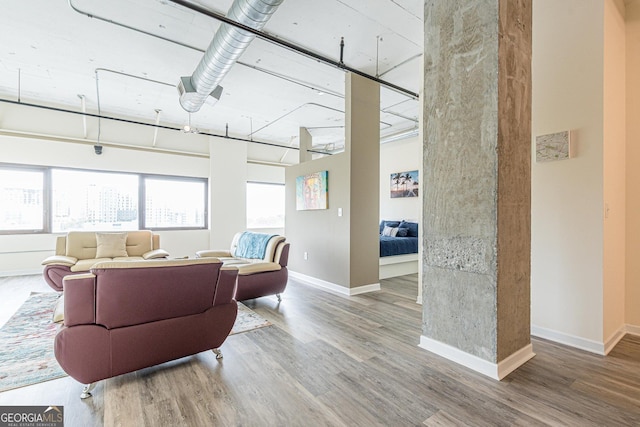 living room with hardwood / wood-style flooring and a towering ceiling