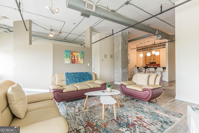 living room with wood-type flooring and an inviting chandelier