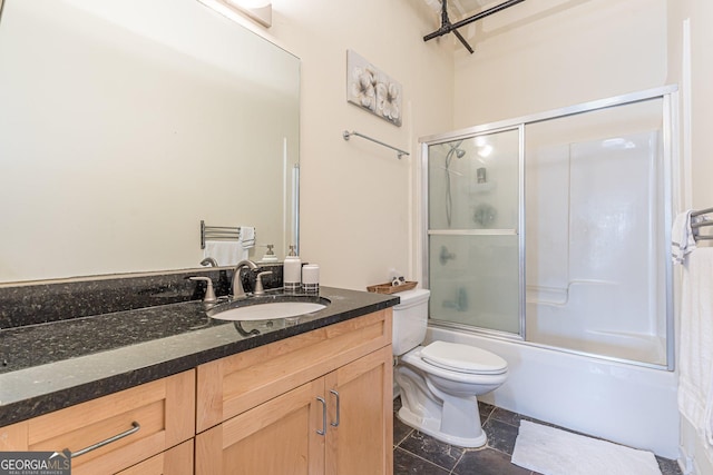 full bathroom featuring vanity, enclosed tub / shower combo, and toilet