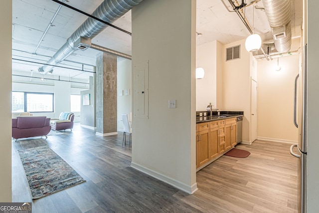 corridor with wood-type flooring and sink