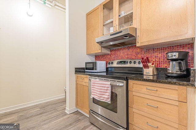 kitchen with tasteful backsplash, dark stone countertops, stainless steel range with electric cooktop, light brown cabinets, and light hardwood / wood-style flooring