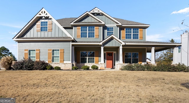 craftsman house featuring covered porch and a front yard