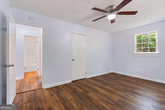 unfurnished bedroom with a textured ceiling, ceiling fan, and dark wood-type flooring