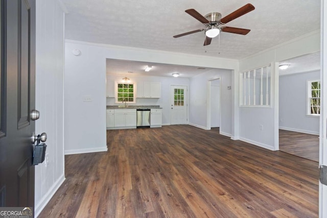 unfurnished living room featuring a textured ceiling, a healthy amount of sunlight, crown molding, dark hardwood / wood-style flooring, and ceiling fan