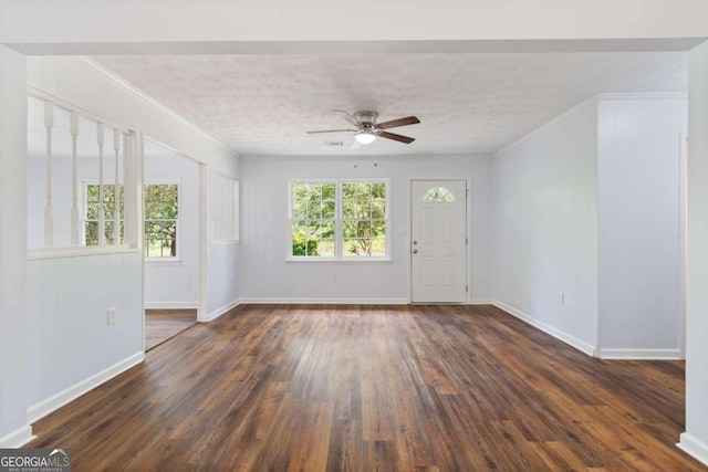 spare room featuring ceiling fan, dark wood-type flooring, ornamental molding, and a textured ceiling