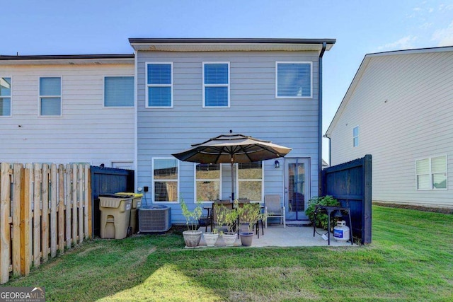 rear view of house with a patio, a yard, and central AC