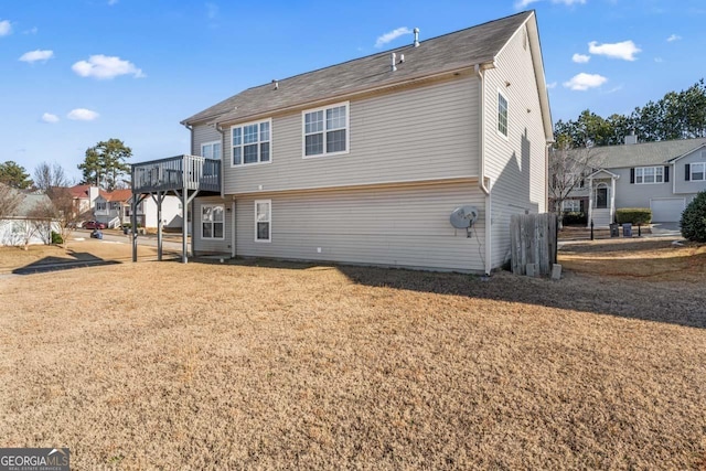 rear view of house with a deck and a lawn