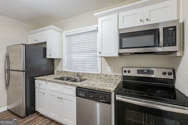 kitchen featuring light stone countertops, dark hardwood / wood-style floors, stainless steel appliances, white cabinetry, and sink