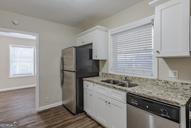 kitchen featuring sink, white cabinets, light stone counters, and appliances with stainless steel finishes