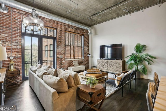 living room with dark wood-type flooring, french doors, and brick wall