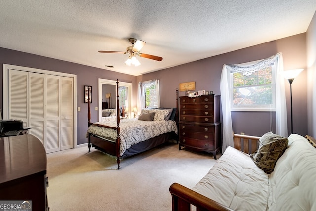 carpeted bedroom featuring ceiling fan, a closet, and a textured ceiling