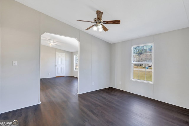 empty room featuring dark wood-type flooring, ceiling fan, and vaulted ceiling