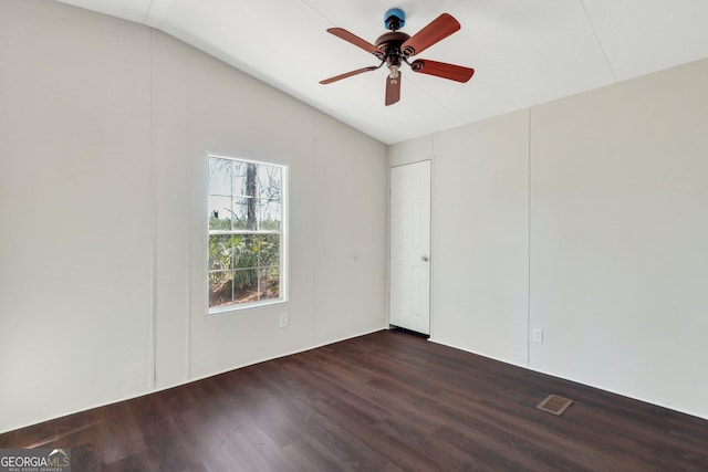 empty room featuring ceiling fan, vaulted ceiling, and dark wood-type flooring