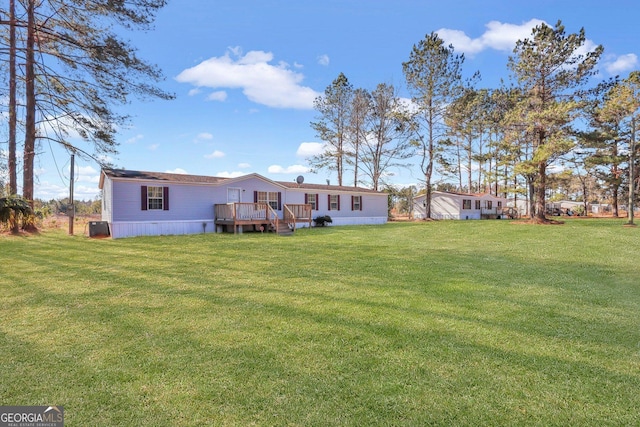 back of house featuring a yard and a wooden deck