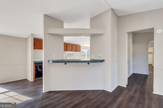 kitchen with a breakfast bar area, dark wood-type flooring, stove, and kitchen peninsula