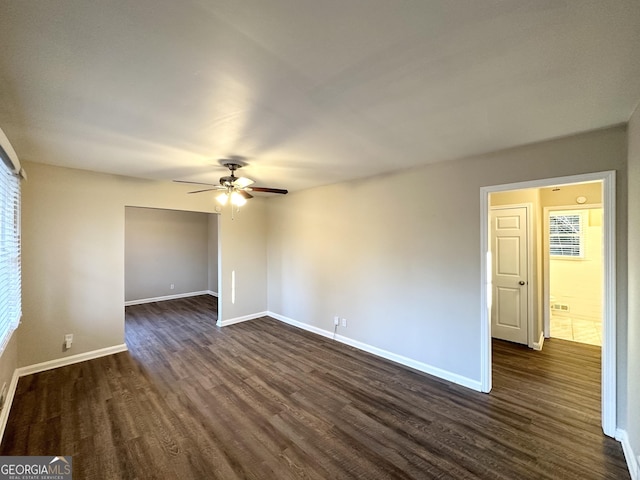 empty room featuring dark wood-type flooring and ceiling fan