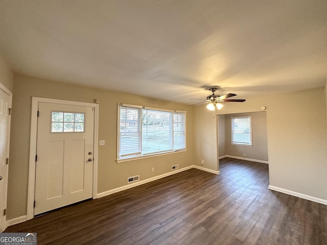 entrance foyer with ceiling fan, dark wood-type flooring, and a wealth of natural light