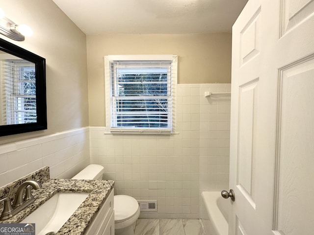 bathroom with toilet, vanity, tile walls, and a bath