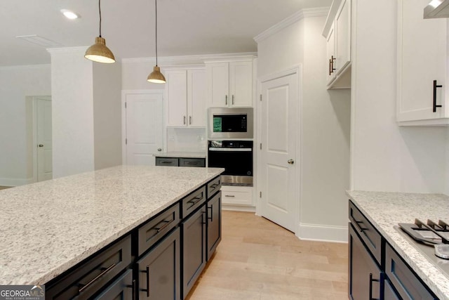 kitchen with light wood-style floors, white cabinetry, appliances with stainless steel finishes, and ornamental molding