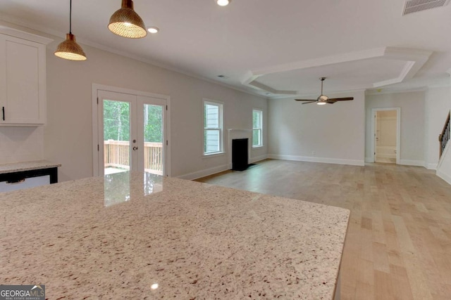 kitchen with ornamental molding, a tray ceiling, white cabinets, and visible vents