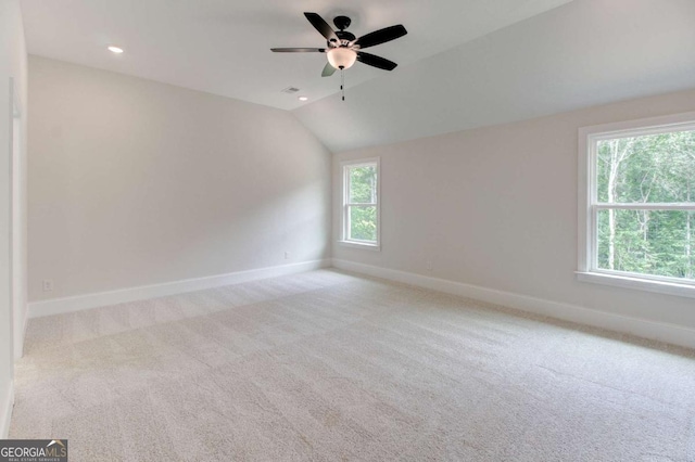 carpeted spare room with lofted ceiling, baseboards, and recessed lighting