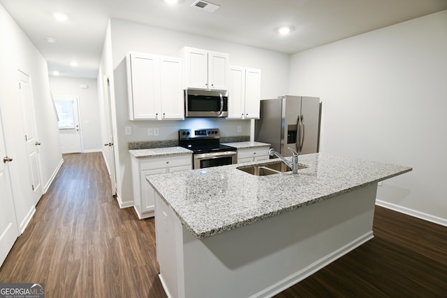 kitchen with appliances with stainless steel finishes, white cabinets, a kitchen island with sink, and sink