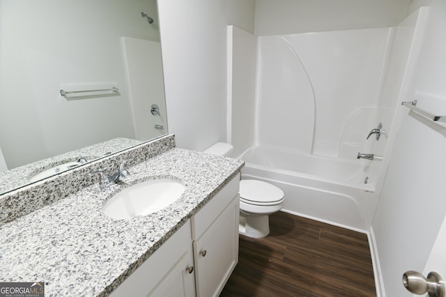 full bathroom with toilet, vanity, hardwood / wood-style floors, and washtub / shower combination