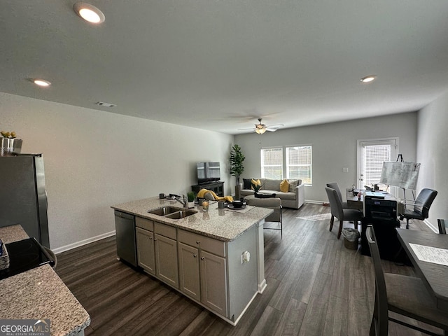 kitchen with sink, dark hardwood / wood-style flooring, an island with sink, and appliances with stainless steel finishes